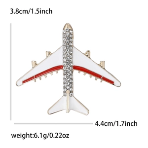 Golden alloy airplane brooch with white enamel wings and sparkling crystal rhinestones
