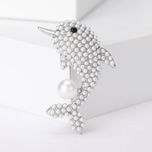 Close-up of elegant dolphin brooch with silver base and multiple white pearls
