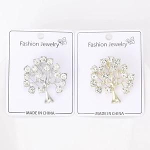 Vue détaillée des broches arbre de vie en or et argent avec des cristaux de strass brillants