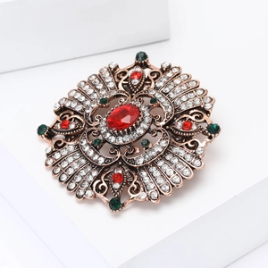 Macro shot of Baroque vintage brooch featuring a large red gemstone and crystal inlay