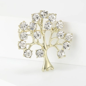 Détail d'une broche arbre dorée avec branches polies et cristaux transparents