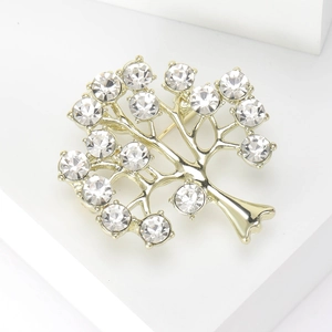 Gros plan d'une broche arbre dorée élégante ornée de cristaux de strass étincelants