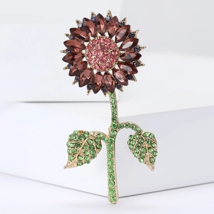 Detail of sunflower brooch with pink and red rhinestones on a gold metal base