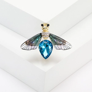 Macro shot of bee brooch featuring a large blue crystal and diamond-encrusted wings