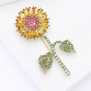 Elegant crystal sunflower brooch with yellow petals and green leaves on white base