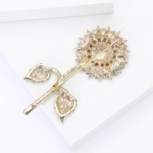 Detail view of the gold-plated alloy sunflower brooch showing pin mechanism and texture