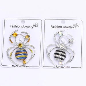 Detailed macro view of crystal spider brooches in blue and black stripes on cards