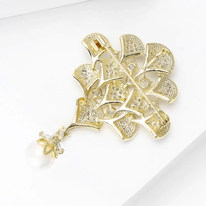 Détails de la broche plume de paon de luxe avec zircons scintillants et perle blanche pendante
