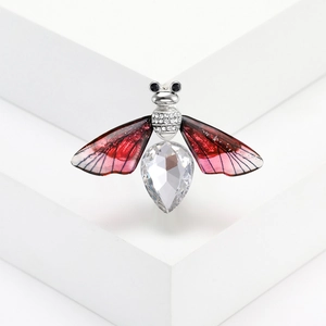 Macro shot of silver bee brooch with large crystal drop and red translucent wings