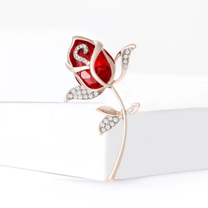 Eleganter roségoldener Blumenanstecker mit großem rotem Kristall und funkelnden weißen Strasssteinen