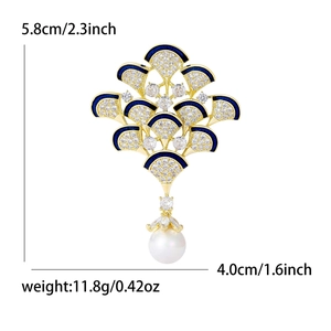 Broche élégante en forme de plume de paon, émail bleu, zircons et une perle blanche ronde