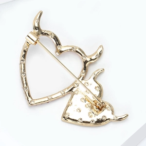 Detail view showing the golden heart brooch back with a secure rotating safety pin clasp