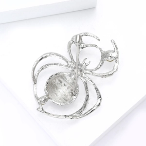 Macro shot of spider brooch back with rotating safety clasp and silver metal texture