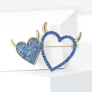 Exquisite gold heart brooch with blue rhinestones and devil horns on white background