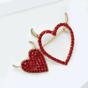 Detailed close-up of devil heart brooch featuring red rhinestones and gold horns details