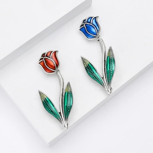 Broches tulipes élégantes en émail rouge et bleu sur un podium blanc minimaliste