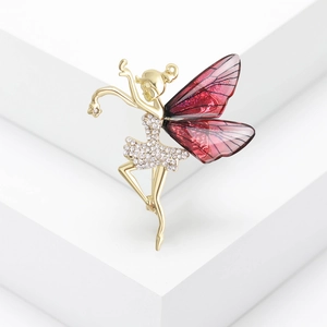 Broche fée dorée élégante avec ailes rouges et strass sur un escalier blanc pur