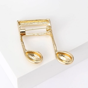 Minimalist golden music note brooch with glossy metal finish and secure safety pin