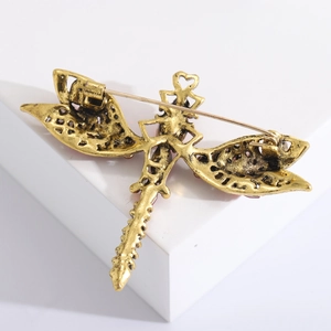 Detailed back view showing the antique gold metal pin and clasp of the dragonfly brooch