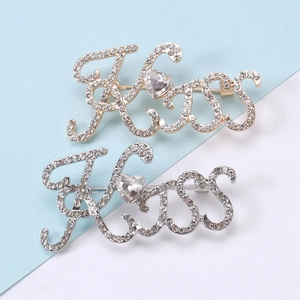 Spille alla moda con lettere Kiss in strass e gemma a cuore in finitura oro e argento