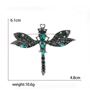 Vintage dragonfly brooch with green crystals and rhinestones measuring 6.1cm by 4.8cm