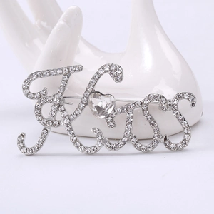 Dettaglio della spilla Kiss argento con strass scintillanti e zircone a cuore