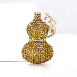 Macro shot of luxury gourd brooch with amber rhinestones and golden cloud motifs