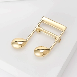 Macro shot of gold musical note brooch with polished finish and secure back pin closure
