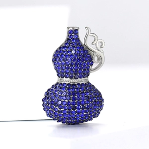 Macro shot of luxury gourd-shaped brooch with blue crystals and intricate silver details