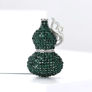 Detailed view of silver gourd brooch with deep green rhinestones and intricate engraving