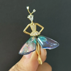 Detailansicht der goldenen Ballerina-Brosche mit lila Farbverlauf und funkelnden Kristallen