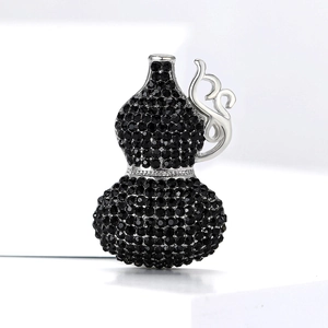 Close-up of luxury gourd brooch featuring black rhinestones and intricate metal patterns