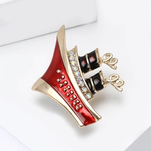 Detailed close-up of a steamship brooch featuring red enamel and colorful rhinestones