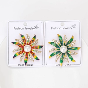 Vue détaillée de broches tournesols en émail coloré avec perles sur carte en papier