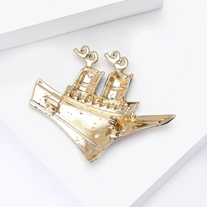 Macro shot showing the secure pin back and golden metallic finish of the steamship brooch