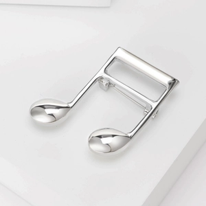Detail of high-polished silver musical note brooch with elegant double-note design