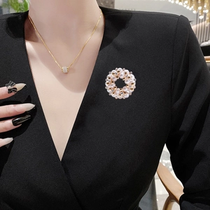 Elegante ronde parelkrans broche met kristallen op een goudkleurige legering