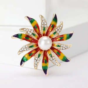 Broche fleur colorée avec perle centrale et strass sur fond blanc épuré
