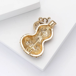 Macro detail of the back structure and secure pin clasp of this gold gourd-shaped brooch