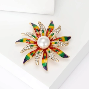 Détail de la broche fleur en émail avec strass et une grande perle centrale incrustée