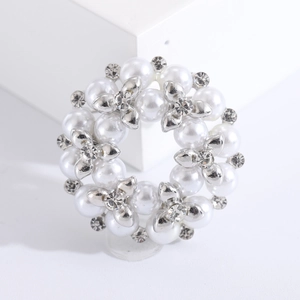 Elegante zilveren kransbroche met witte parels en fonkelende kristallen op witte basis