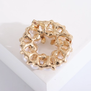 Detailweergave van de achterkant van de gouden parelbroche met de sluiting en afwerking