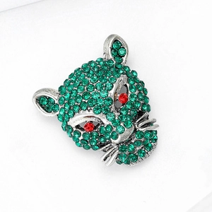Detail of silver leopard head brooch featuring green crystals and red gemstone eyes