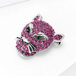 Macro detail of silver leopard head brooch with pink rhinestones and green eyes