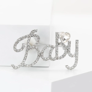 Détail de la broche Baby argentée sertie de strass avec un cristal en forme de cœur