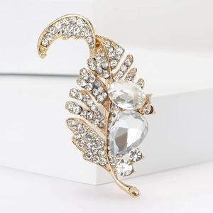 Detailed macro view of vintage gold leaf brooch with sparkling crystals and pear-shaped stones