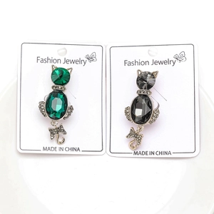 Detail of elegant alloy cat brooches with emerald and grey crystals and rhinestones