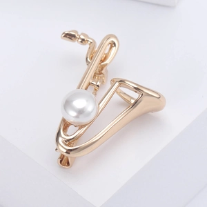 Broche saxophone dorée élégante avec perle blanche sur un bloc minimaliste blanc