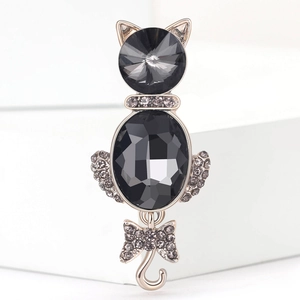 Macro detail of the cat brooch featuring dark gemstones and sparkling crystal accents