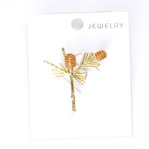 Detail view of a vintage pine cone brooch with orange crystals and gold-tone finish